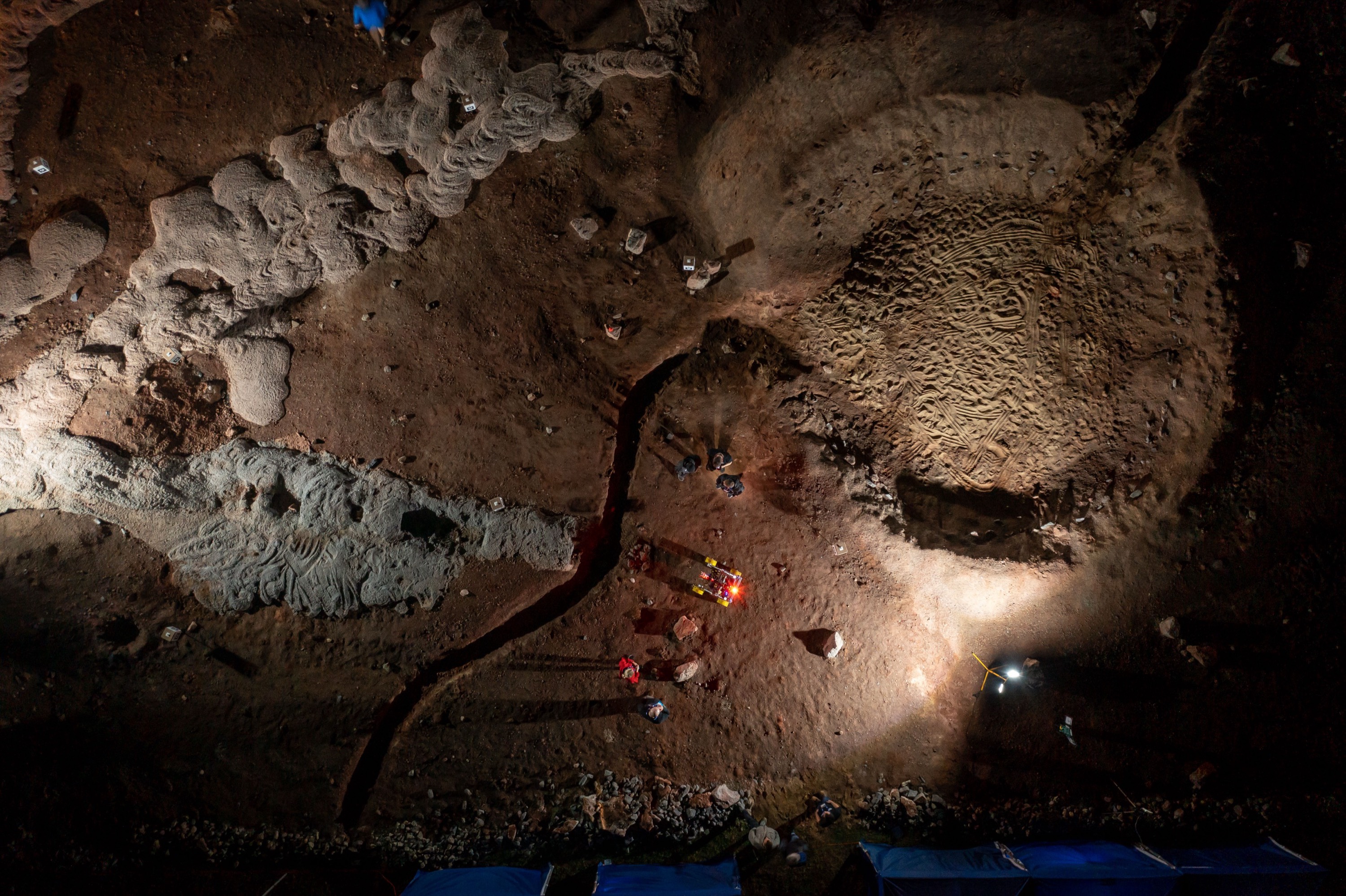 Aerial night view of the European Rover Challenge Marsyard — the rover spotlit among crater-like terrain