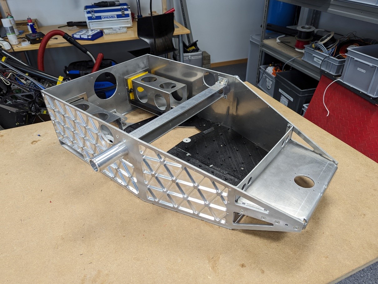 The bare CNC-machined aluminium rover chassis on a workbench