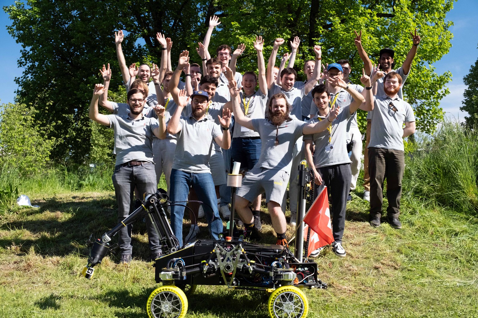 The FHNW Rover Team celebrating with their rover — arm, deep-sampling drill and Swiss flag on board